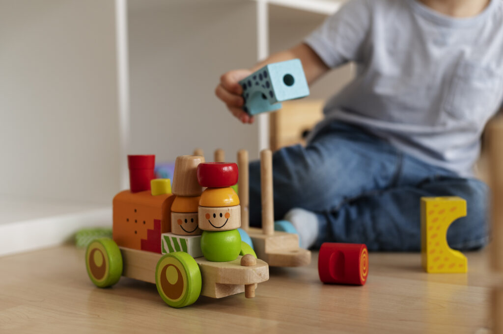 Dziecko bawi się drewnianymi zabawkami w żłobku